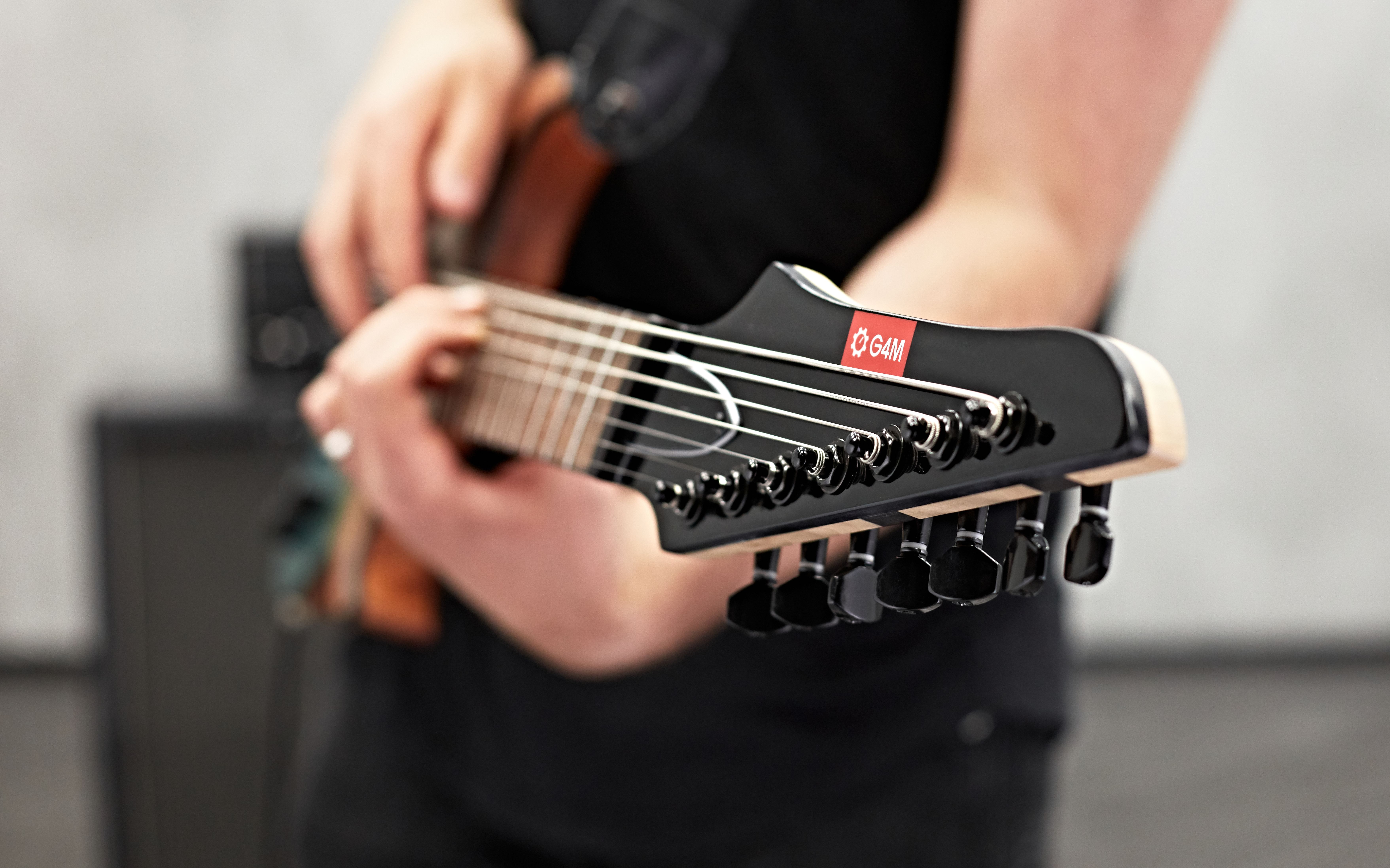 Close up of the head of a G4M guitar being played